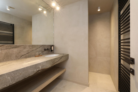 Baño moderno con encimera de piedra, espejo grande y ducha en Lodge at Woodz Lodges en Bélgica.