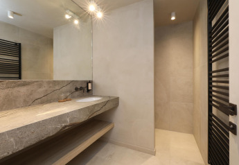 Baño moderno con encimera de piedra, espejo grande y ducha en Lodge at Woodz Lodges en Bélgica.