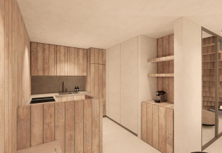 Cocina moderna revestida de madera y entrada en Group Lodge de Woodz Lodges, Bélgica, con escalera visible.