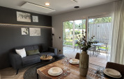 Moderne stue og spiseområde i Domus 4 chalet på Zilverstrand i Belgien, med udsigt til terrasse og have.