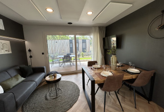 Soggiorno e sala da pranzo moderni nel chalet Domus 4 a Zilverstrand, Belgio, con vista sul patio.
