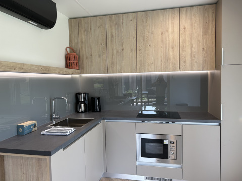 Cuisine moderne dans le chalet Domus 4 au Zilverstrand, Belgique, avec des placards en bois et électroménagers encastrés.