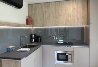 Moderne keuken in chalet Domus 4 op Zilverstrand in België, met houten kasten en ingebouwde toestellen.