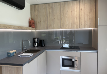 Moderne keuken in chalet Domus 4 op Zilverstrand, België, met houten kasten en ingebouwde apparatuur.