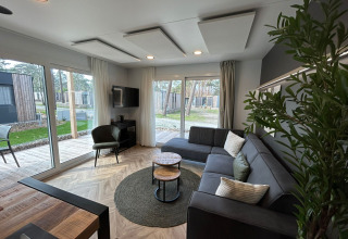 Moderne woonkamer in Belsano 6 lodge op Zilverstrand, België, met grote ramen en hedendaags interieur.