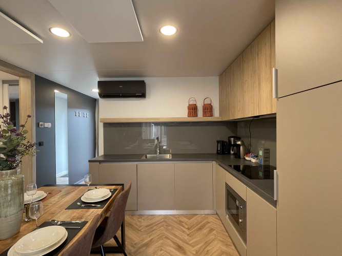 Cucina moderna e zona pranzo al Belsano 6 lodge di Zilverstrand, Belgio, con arredi di design elegante.