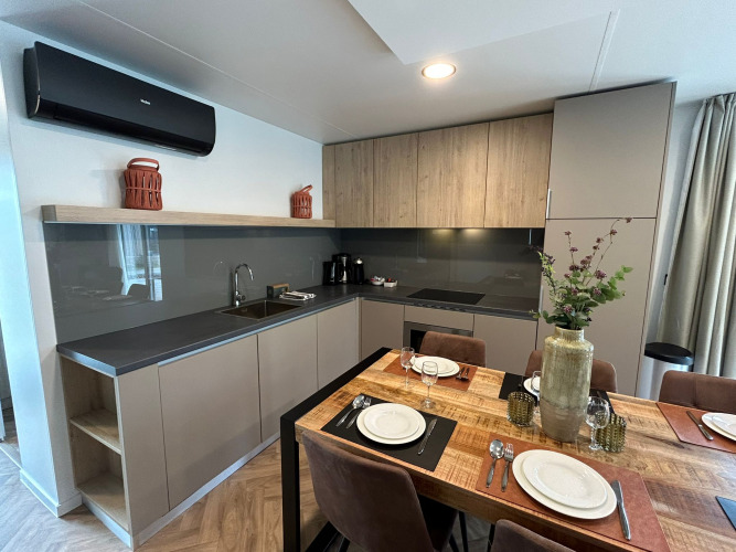 Cocina moderna y comedor en la cabaña Belsano 6 en Zilverstrand, Bélgica, decorado con buen gusto.