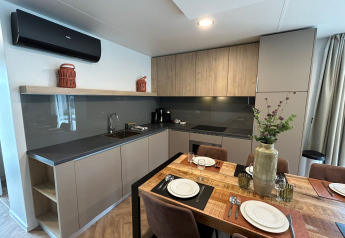 Cocina moderna y comedor en la cabaña Belsano 6 en Zilverstrand, Bélgica, decorado con buen gusto.