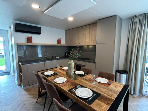 Moderne keuken en eetkamer met zes gedekte borden in Belsano 6 lodge op Zilverstrand, België, interieur.