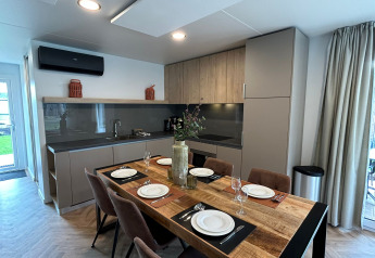 Cocina moderna y comedor para seis en el lodge Belsano 6 de Zilverstrand, Bélgica, vista interior.