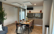 Modern dining area and kitchen in the Belsano 6 lodge at Zilverstrand, Belgium, with stylish decor.
