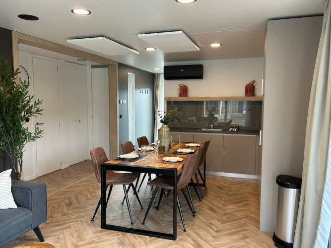 Zona pranzo e cucina moderna nel lodge Belsano 6 a Zilverstrand, Belgio, con arredo elegante.