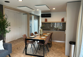 Moderne eetkamer en keuken in de Belsano 6 lodge op Zilverstrand, België, met stijlvol decor.