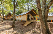 Safari-Zelt Bella Vista mit Klimaanlage in einem bewaldeten Campingbereich mit Natur und Ruhe.