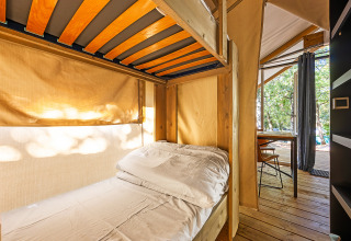 Innenaufnahme des Safari-Zeltes Bella Vista mit Etagenbett, Holzmöbeln und Blick nach draußen.