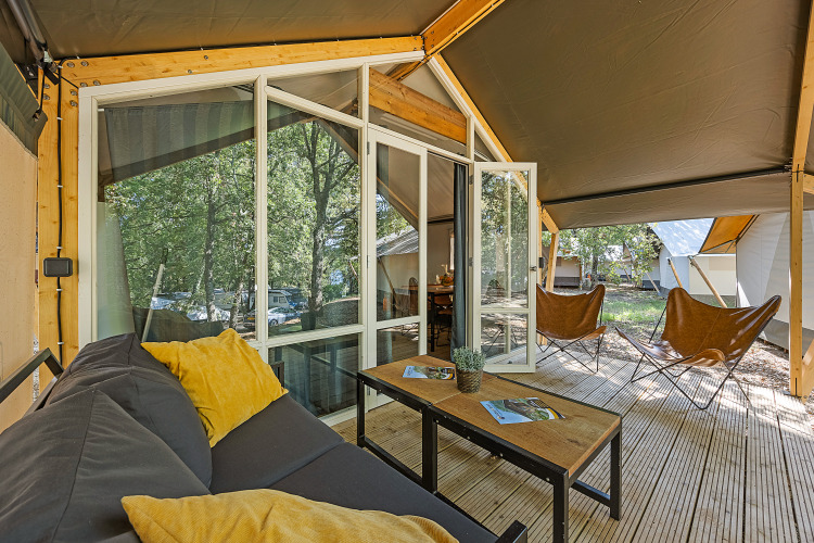 Terras van safaritent Bella Vista met bank en stoelen bij Camping Porto Sole, Kroatië, omgeven door natuur.