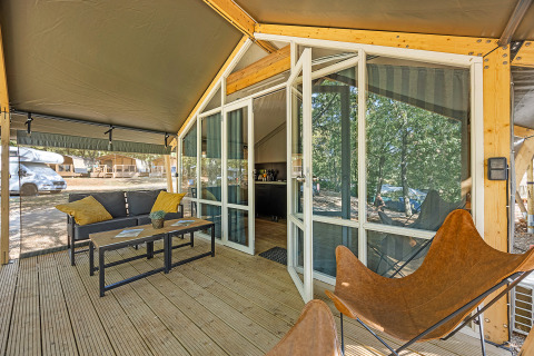 Terraza y entrada de la tienda Safari Bella Vista con muebles modernos y aire acondicionado en Camping Porto Sole.