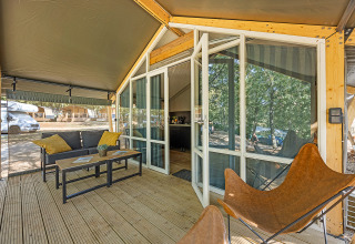 Terrasse et entrée de la tente Safari Bella Vista avec mobilier moderne et climatisation au Camping Porto Sole.