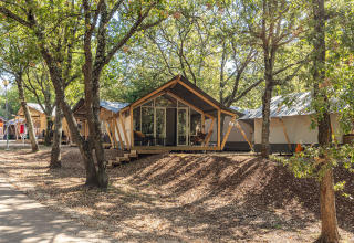 Tente safari Bella Vista climatisée au Camping Porto Sole en Croatie, entourée d'arbres et de verdure.