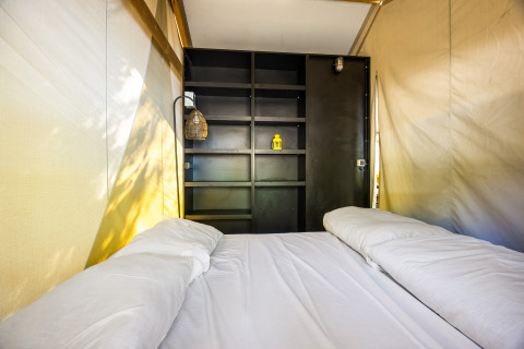 Innenaufnahme des Safari-Zelts Bella Vista mit Klimaanlage und Doppelbett auf Camping Porto Sole.