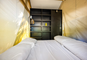 Vista interna della tenda Safari Bella Vista con aria condizionata e letto matrimoniale al Camping Porto Sole.