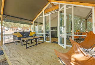 Tienda safari Bella Vista con aire acondicionado, terraza de madera y mobiliario moderno al aire libre.