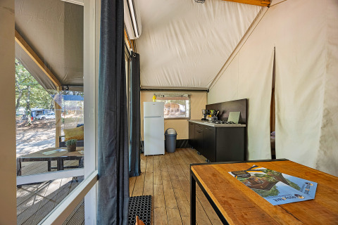 Indvendigt billede af Safari telt Bella Vista med aircondition på Camping Porto Sole i Kroatien, visende køkken og opholdsrum.