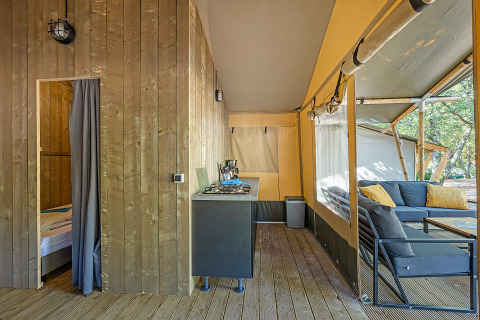 Interior de una tienda safari con aire acondicionado y zona de descanso en Camping Lanterna, Croacia.