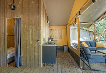 Interno di una tenda safari lodge con aria condizionata e area lounge al Camping Lanterna, Croazia.