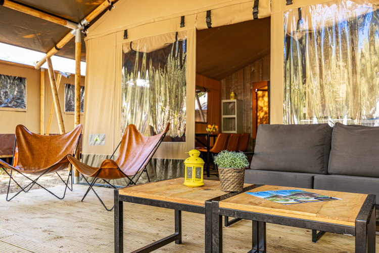 Outdoor seating area at Safari tent Lodge with air conditioning at Camping Lanterna, Croatia.