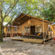 Safari telt Lodge med aircondition, udendørs terrasse og siddepladser omgivet af træer i skovmiljø.