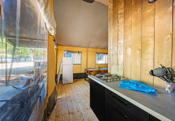 Indvendigt billede af et safari telt Lodge med aircondition, viser køkken, spisebord og køleskab.