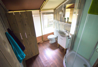 Baño con paredes de madera y comodidades modernas en una tienda safari en Camping Valkanela, Croacia.