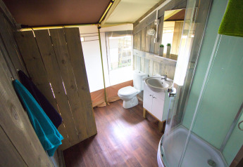 Bagno con pareti in legno e servizi moderni in una tenda safari presso Camping Valkanela, Croazia.