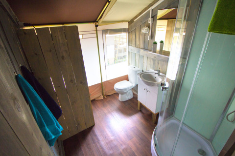 Baño con paredes de madera y comodidades modernas en una tienda safari en Camping Valkanela, Croacia.