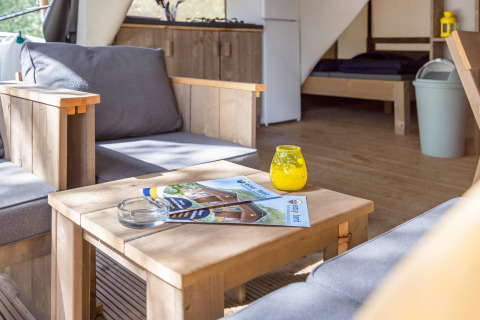 Interno di Safari Tent Comfort al Camping Porto Sole in Croazia con mobili in legno e divani.