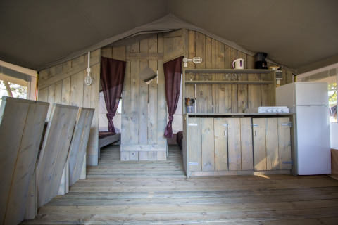 Vista interior de la cocina y el comedor de una Safari Tent Luxury en Camping Valkanela, Croacia.