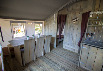 Interno della Safari Tent Luxury al Camping Valkanela in Croazia, con mobili in legno e stile rustico.