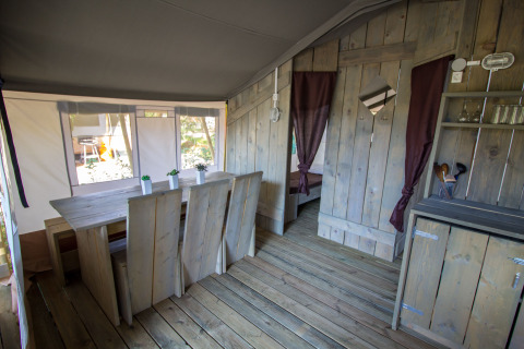 Interno della Safari Tent Luxury al Camping Valkanela in Croazia, con mobili in legno e stile rustico.
