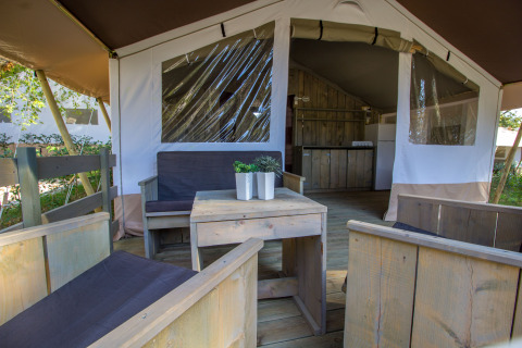Innenansicht eines luxuriösen Safari-Zeltes auf Camping Valkanela in Kroatien mit Holzterrasse und Pflanzen.