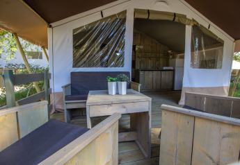 Innenansicht eines luxuriösen Safari-Zeltes auf Camping Valkanela in Kroatien mit Holzterrasse und Pflanzen.