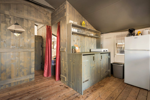 Binnenaanzicht van de Safari Tent Luxury op Camping Lanterna in Kroatië met keuken en houten wanden.