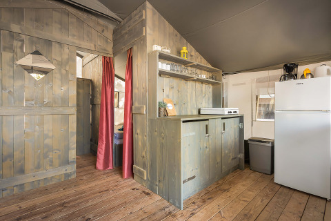 Vista interior de la Safari Tent Luxury en Camping Lanterna, Croacia, con cocina y paredes de madera.