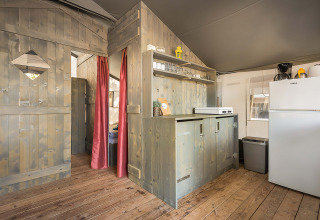 Binnenaanzicht van de Safari Tent Luxury op Camping Lanterna in Kroatië met keuken en houten wanden.