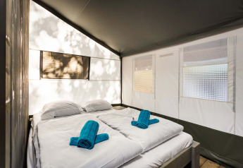 Indretning af Safari Tent Luxury på Camping Lanterna i Kroatien med dobbeltseng og rene håndklæder.