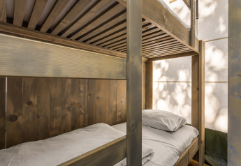 Tremmevæg og etagesenge i Safari Tent Luxury på Camping Lanterna, Kroatien, med naturligt lys.