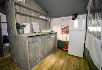 Keukenhoek in een luxe safaritent op Camping Lanterna, Kroatië, met houten kasten en apparatuur.