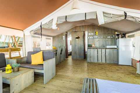 Indretning af Safari Tent Luxury på Camping Lanterna i Kroatien, med køkken, spiseplads og opholdsområde.