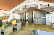 Indretning af Safari Tent Luxury på Camping Lanterna i Kroatien, med køkken, spiseplads og opholdsområde.