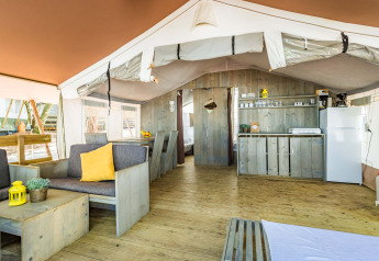 Interno della Safari Tent Luxury al Camping Lanterna in Croazia, con cucina, salotto e zona pranzo.
